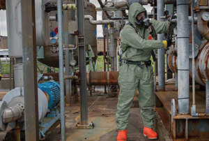 Refinery workers wear green Tychem 2000 SFR flame resistant-disposable hooded protective coveralls