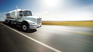 An Airgas truck drives down a road.