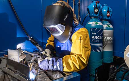 A welder in wearing a RADNOR welding helmets made by 3M Speedglas, MIG welding with ARCAL Shielding Gas