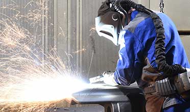 Worker welding in full safety gear