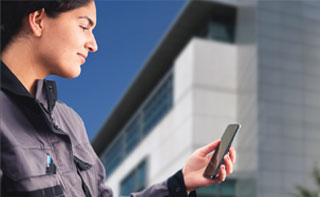 Woman in front of a hospital looking at a phone